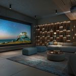 A casual home theater with a sectional, large movie screen, and Sony projector.