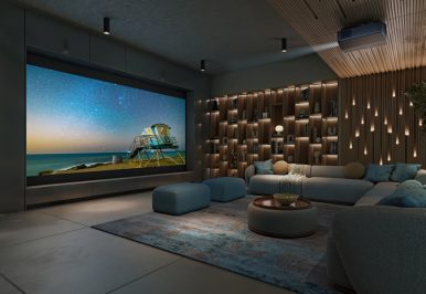 A casual home theater with a sectional, large movie screen, and Sony projector.