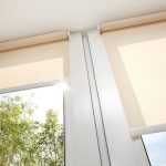 Sun streaming through windows that are partially covered by motorized shades.