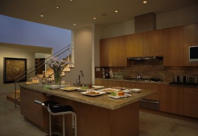 A kitchen with recessed ambient lights, task lighting, and accent lighting.