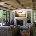 A media room with a wall-mounted TV and in-ceiling speakers.