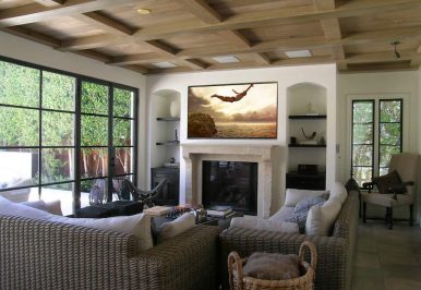A media room with a wall-mounted TV and in-ceiling speakers.