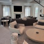 A large open living space featuring in-ceiling speakers and various TV screens.