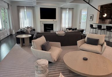 A large open living space featuring in-ceiling speakers and various TV screens.
